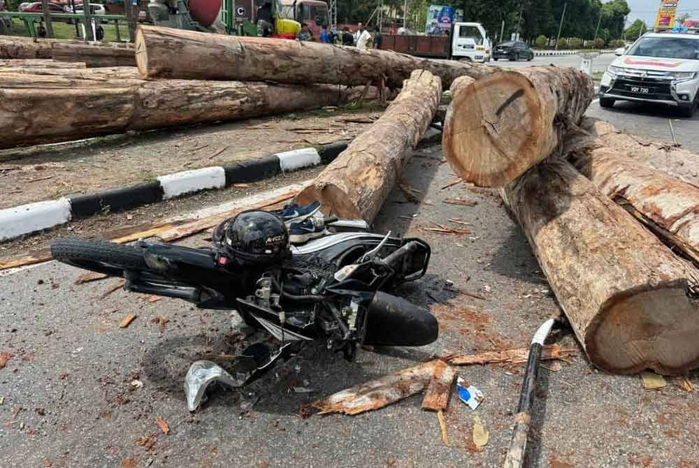 Seorang penunggang motosikal cedera selepas terkena kayu balik yang jatuh dari lori yang terbalik.