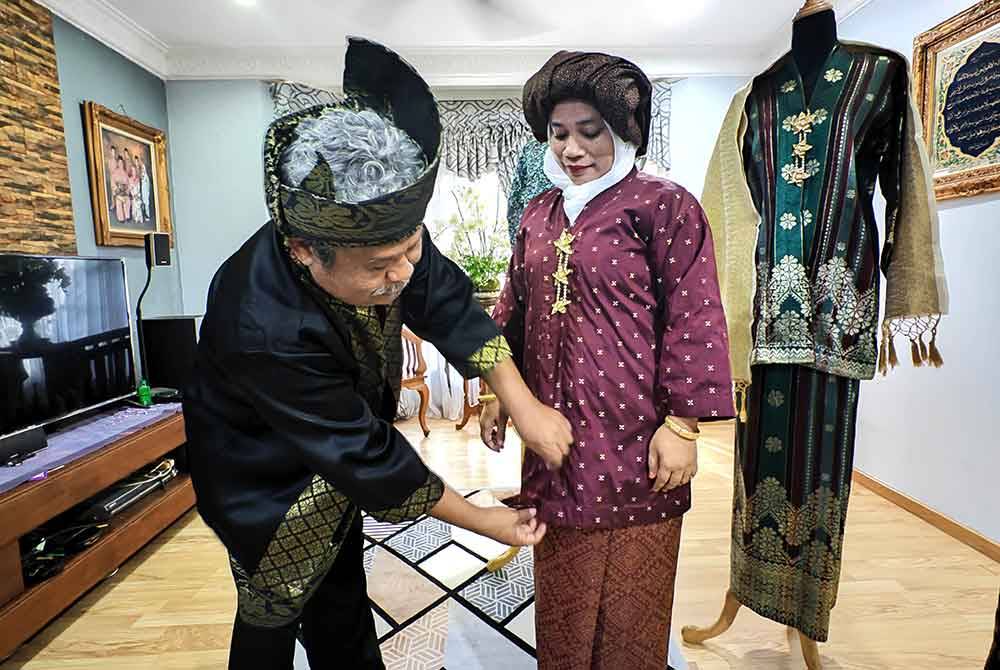 Alias menunjukkan cara pemakaian kebaya setengah tiang yang betul.