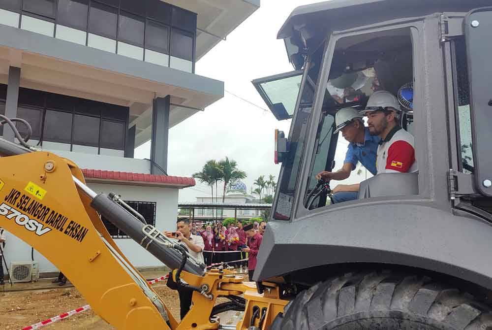 Tengku Amir Shah memandu jengkaut sebagai simbolik perasmian bagi Majlis Pecah Tanah bagi pembinaan Bilik Mesyuarat Bahagian Pembangunan Pejabat Daerah dan Tanah Kuala Selangor.