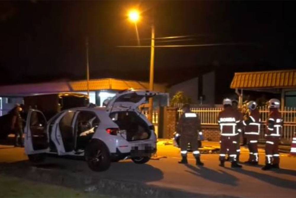 Pasukan penyelamat lengkap dengan pemakaian PPE berjaya membuka pintu kereta yang terkunci menggunakan peralatan khas bagi mengeluarkan dua mayat yang ditemui di dalam kereta di di Taman Sri Rambai, Bukit Mertajam, petang semalam. - Foto Awani