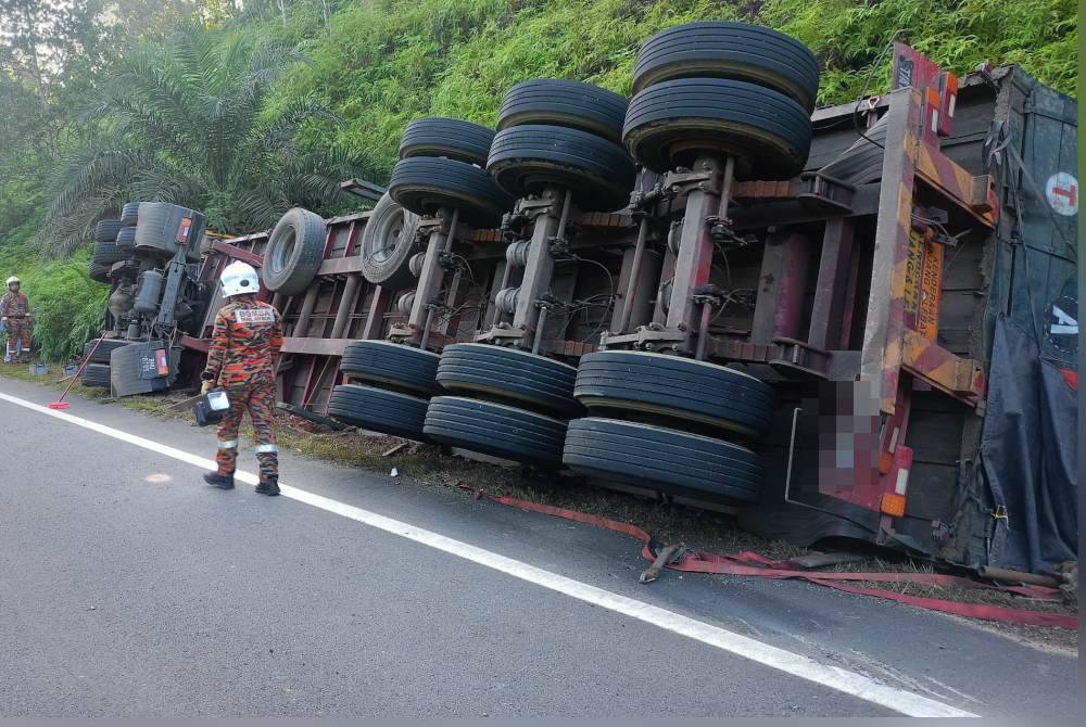 Keadaan treler yang terbalik dalam kemalangan di Kilometer 70 Jalan Gua Musang - Kuala Krai pagi Khamis.