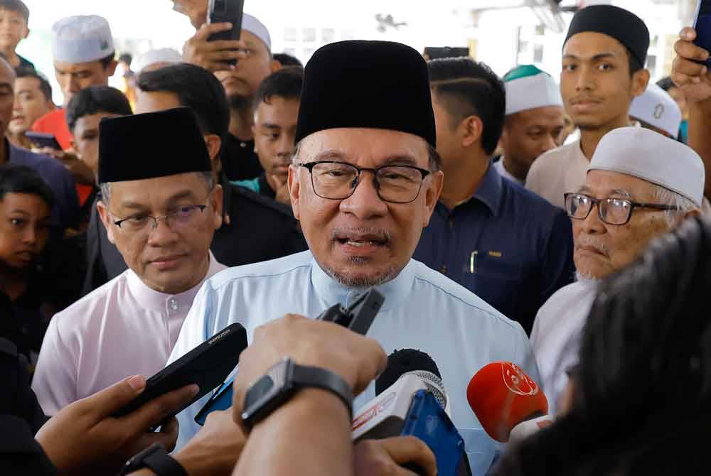 Anwar bercakap pada pemberita selepas menunaikan solat Jumaat di Surau An-Najah, Presint 9, Putrajaya. Foto Bernama