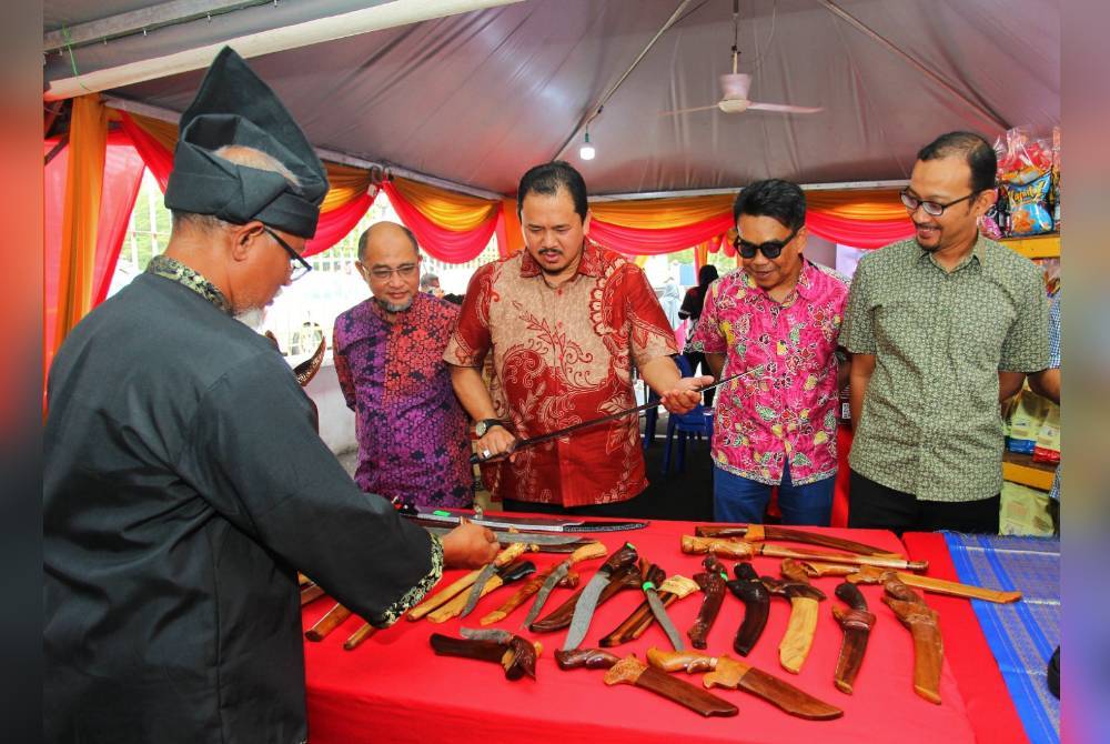 Mohamad Sobri (tiga dari kanan) melihat koleksi senjata warisan Melayu yang dipamerkan sempena perasmian program Semarak@Muzium Perak pada Sabtu.