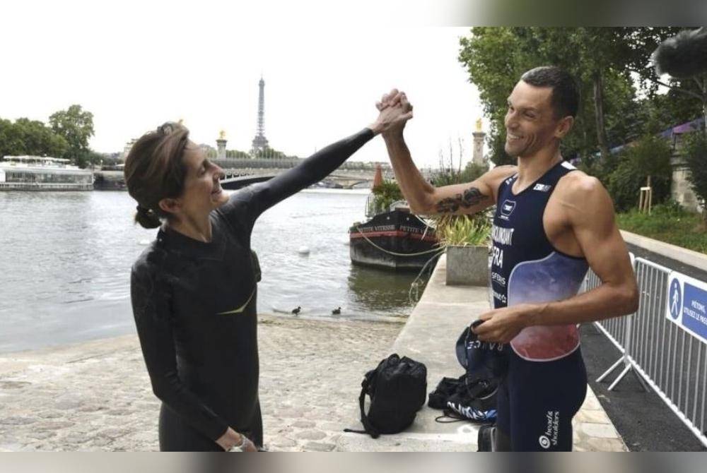 Oudéa-Castéra (kiri) berenang bersama atlet para-triatlon Perancis, Alexis Hanquinquant di Sungai Seine pada Sabtu. Foto AP