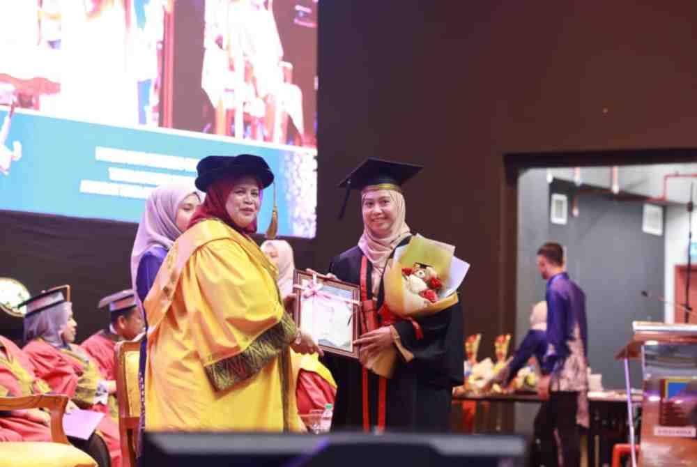 Rubiah (kiri) menyampaikan sijil kepada graduan pada Majlis Graduasi Kolej KEDA ke-12 di Dewan Konvokesyen Universiti Antarabangsa Albukhary di sini pada Ahad.