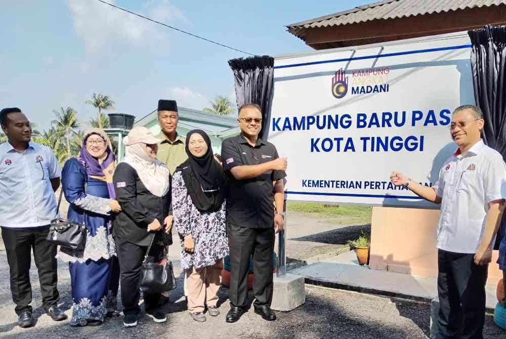 Isham (enam dari kiri), menyempurnakan gimik perasmian Kampung Angkat Madani di Kampung Baru Pasak pada Isnin.