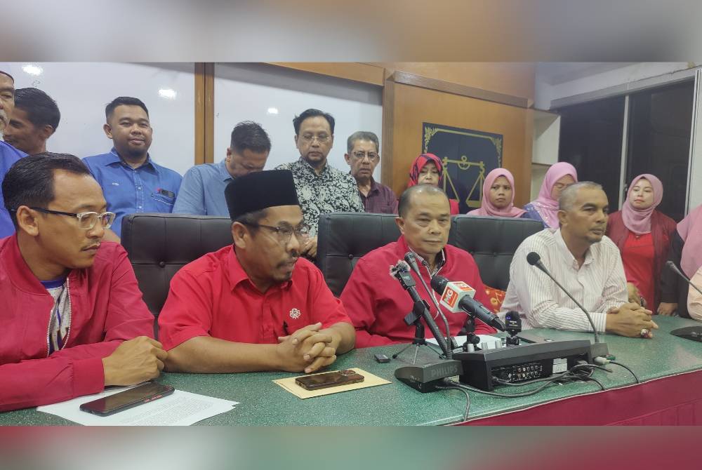 Sulaiman (depan, dua dari kanan) semasa sidang akhbar di Bangunan UMNO Bahagian Tanjong Karang pada Ahad malam.