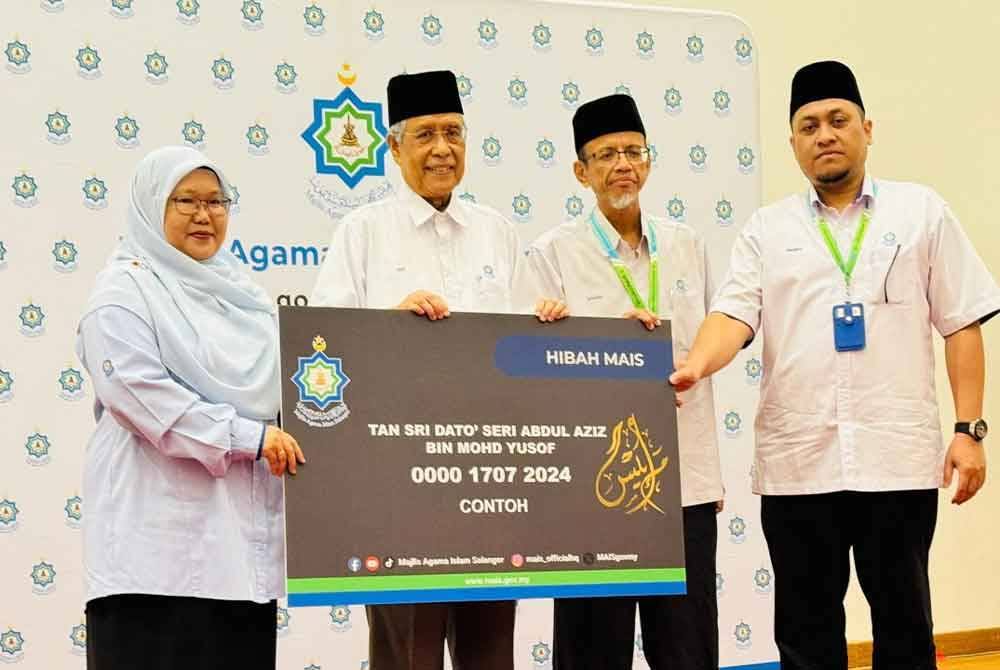 Abdul Aziz (dua dari kiri) memegang replika kad hibah secara simbolik pada Majlis Pelancaran di Masjid Sultan Salahuddin Abdul Aziz Shah pada Rabu.