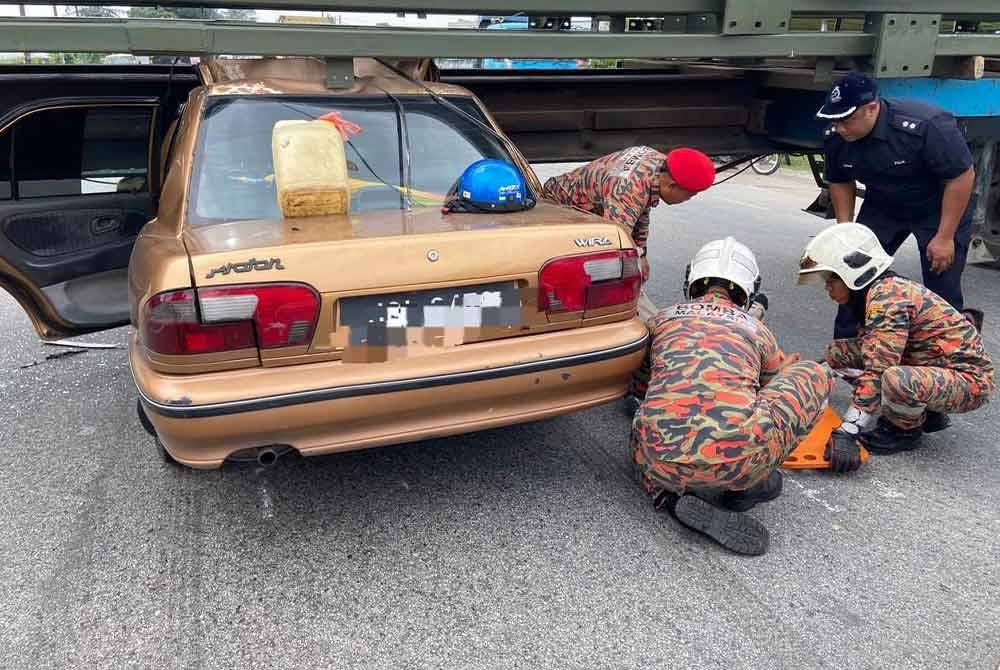 Anggota bomba cuba mengeluarkan mangsa daripada kereta Proton Wira berkenaan. Foto BBP Johor Jaya