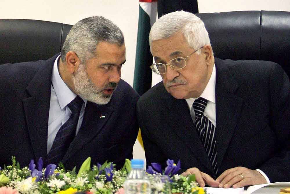 Gambar fail menunjukkan Haniyeh (kiri) bersama Presiden Palestin, Mahmoud Abbas duduk semeja ketika pertemuan di Gaza pada Mac 2007.