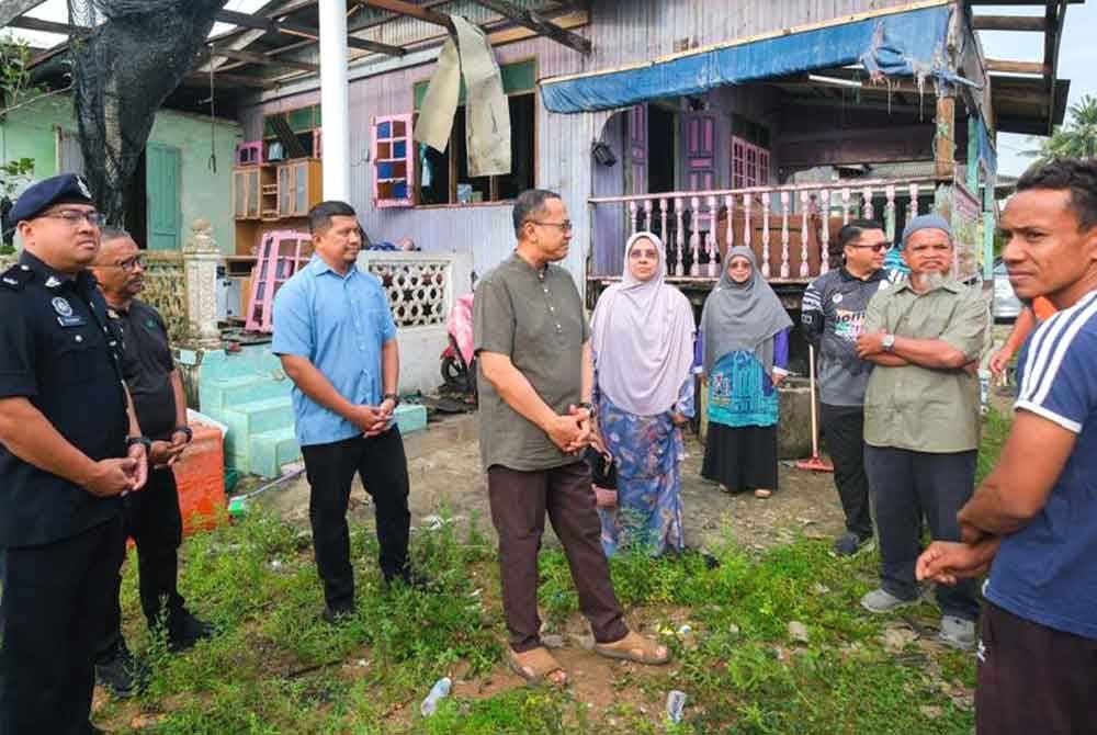 Ahmad Samsuri (empat dari kiri) bersama isteri, Toh Puan Seri Tuan Faezah Tuan Abd Rahman (lima dari kiri) ketika meninjau kerja-kerja membaiki kediaman penduduk yang rosak di Kampung Seberang Marang pada Jumaat.