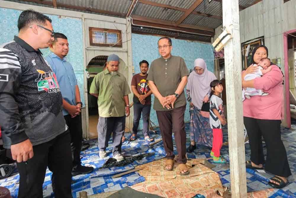 Ahmad Samsuri (tengah) bersama isteri meluangkan masa melawat Siti Aishah sekeluarga di Kampung Pantai Seberang Marang pada Jumaat.