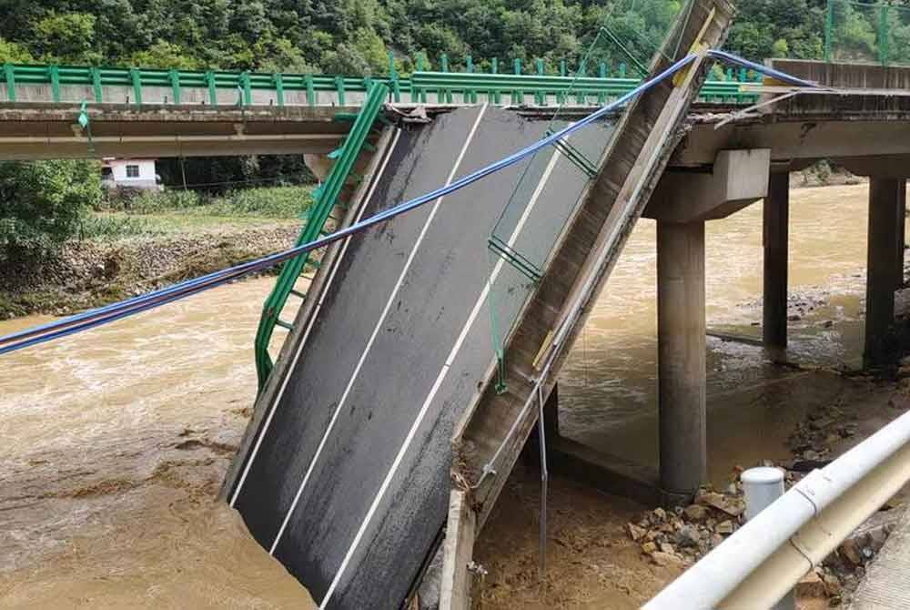 Jambatan yang terletak di Daerah Zhashui, Bandar Shanglu itu sebahagiannya runtuh akibat hujan lebat dan banjir kilat. Foto Xinhua