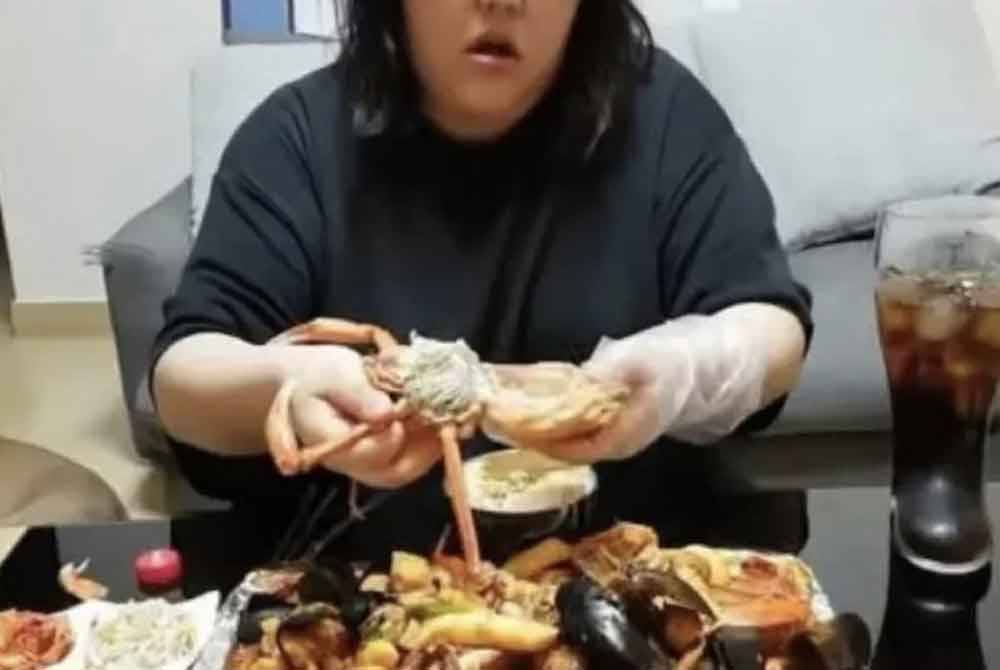 Pan Xiaoting melakukan penstriman langsung semasa mukbang dalam studio di rumah sewanya baru-baru ini. - Foto: Agensi