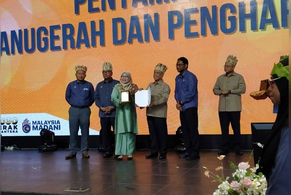 Saarani (tiga dari kanan) menyampaikan sumbangan dan insentif kepada pelajar yang memperoleh keputusan cemerlang dalam Sijil Pelajaran Malaysia sempena Program Santuni Masyarakat Orang Asli dan Simposium Batin 2024 di Galasa Caldwell di sini pada Isnin.