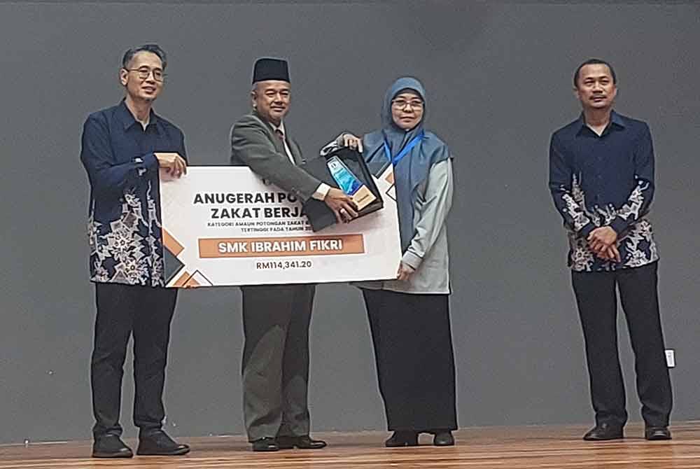 Nazli Amirri (kiri) ketika menyampaikan Anugerah Amaun tertinggi Potongan Zakat Berjadual pada tahun 2023 kepada wakil SMK Fikri