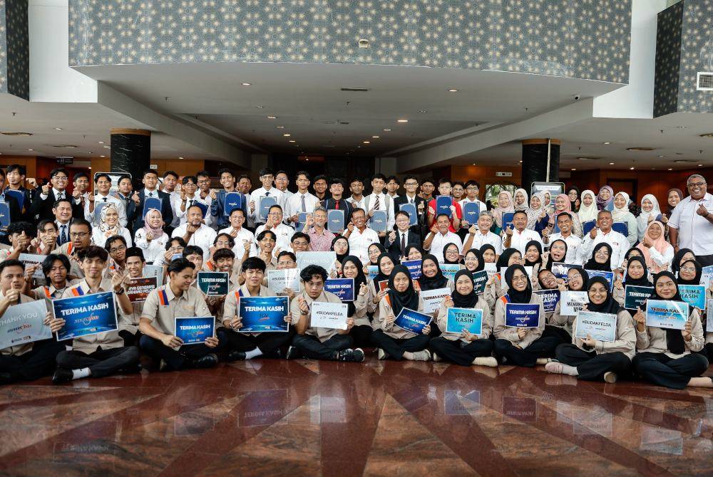 Ahmad Shabery bergambar bersama penerima tajaan pada Majlis Penyerahan Tajaan Program Global Digital Leadership (GDL) di Dewan Perdana Felda pada Rabu. Foto Bernama