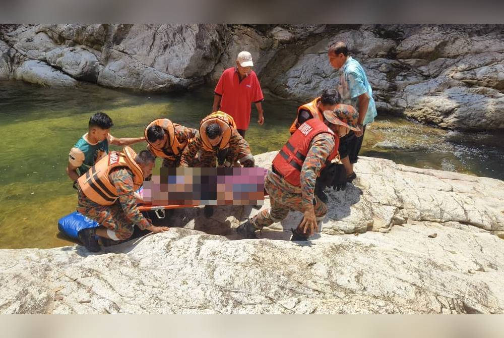 Anggota bomba mengangkat mayat mangsa yang dijumpai pada jarak 10 meter dari dasar lubuk di kawasan air terjun tersebut.