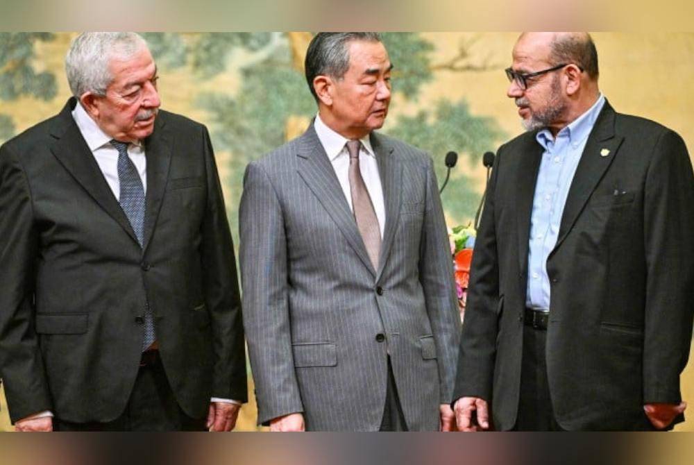 Menteri Luar China, Wang Yi (tengah) dan Naib Pengerusi Jawatankuasa Pusat Pertubuhan Palestin, Mahmoud al-Aloul (kiri) dan anggota kanan Hamas, Mussa Abu Marzuk semasa tiba di Beijing. Foto AFP