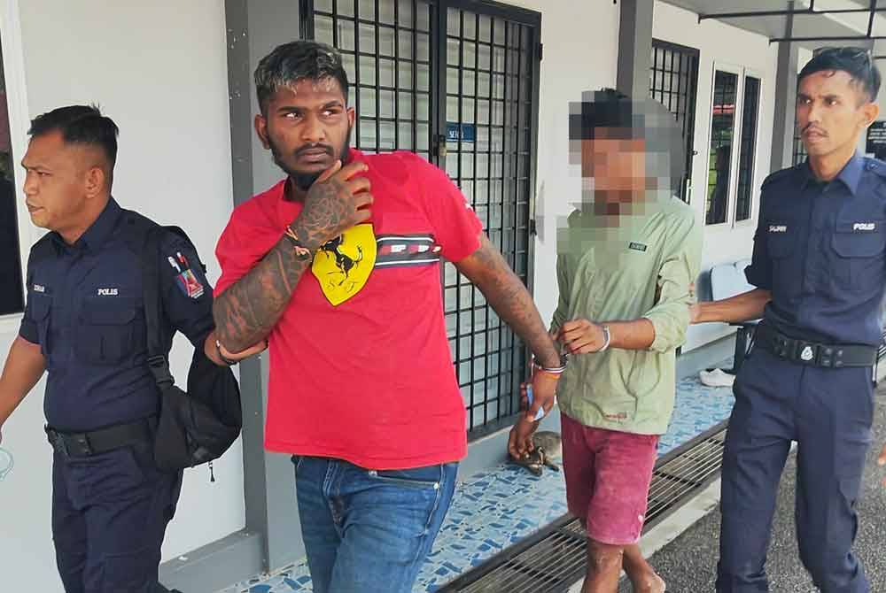 Thava Murali Tharan (berbaju merah) diiring polis ketika hadir ke mahkamah.