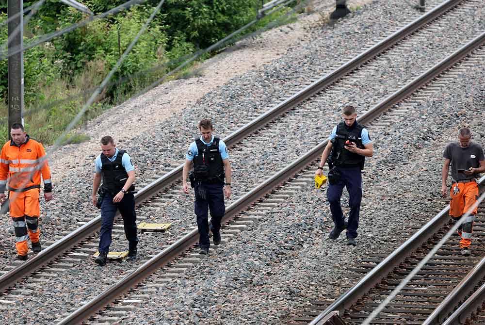 Kakitangan SNCF dan Gendarmes Perancis memeriksa lokasi yang menjadi sasaran perbuatan khianat
di Croiselles, Perancis Utara. Foto AFP