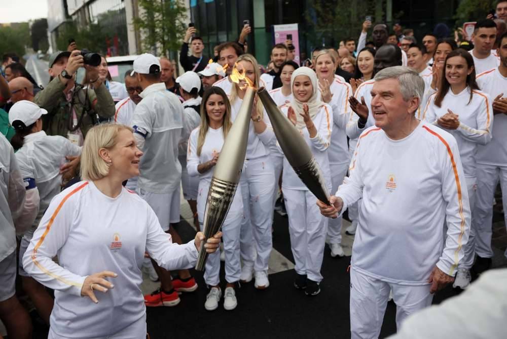 Pengerusi Suruhanjaya Atlet IOC, Emma Terho (kiri) dan Thomas Bach mengambil bahagian dalam acara larian obor kampung Olimpik di Kampung Olimpik Paris, menjelang perasmian Paris 2024. Foto AFP