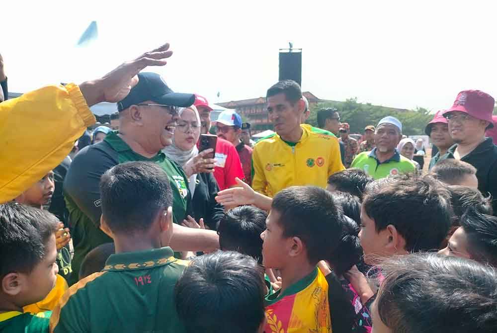 Muhammad Sanusi melayani kanak-kanak yang hadir ke Gotong-Royong Perdana dan Mega Perangi Aedes di Padang Awam Taman Ria Sungai Petani, pada Sabtu.