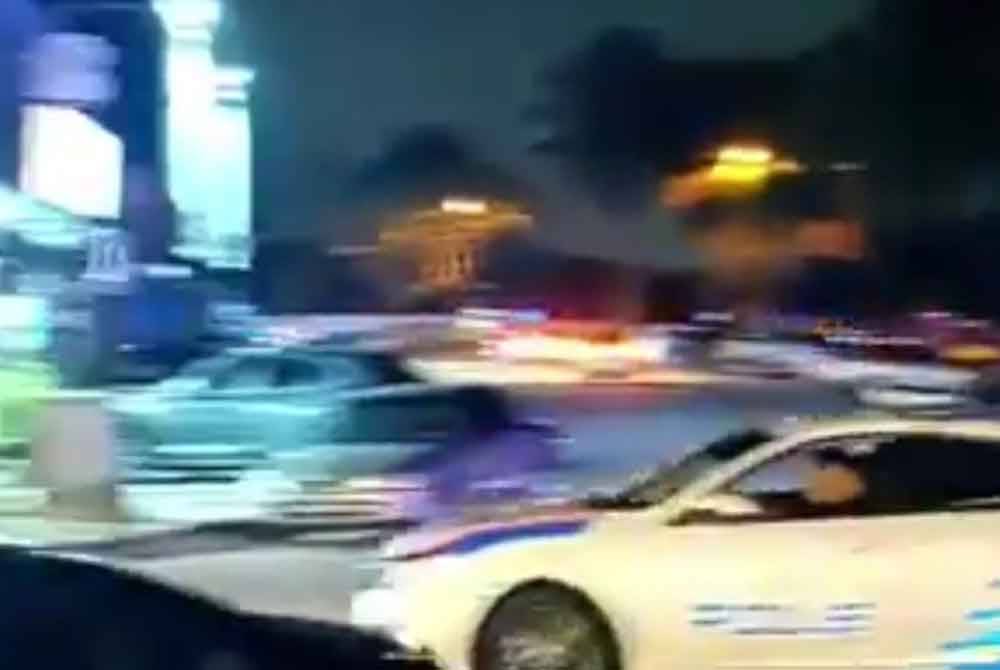 Tangkap layar video tular memaparkan enam MPV polis mengejar sebuah kereta di Taman Impian Emas, Skudai.