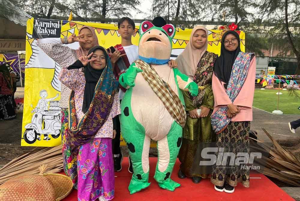 SMK Putrajaya Presint 9 (2) tampil membuat kelainan dengan membawakan maskot katak bagi menarik pengunjung membeli di reruai mereka.