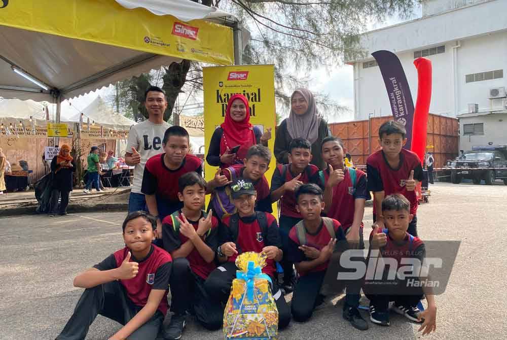 Siti Incah (tengah) bersama 10 murid-murid SK Kampung Johan Setia menyertai acara sukan rakyat di Karnival Rakyat Karangkraf pada Sabtu.