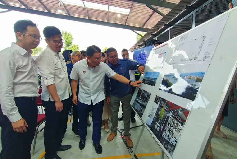 Kor Ming (tiga dari kiri) mendengar taklimat ringkas berkaitan reka bentuk pembangunan semula Pasar Pasir Pinji.