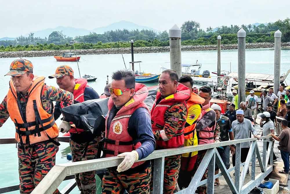 Anggota penyelamat membawa naik mayat mangsa di jeti LKIM Kuala Chenang.