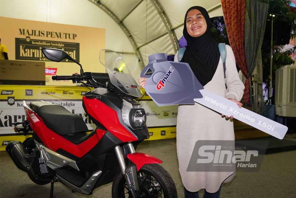 Nur Syazwani bergambar disamping motosikal yang dimenanginya.