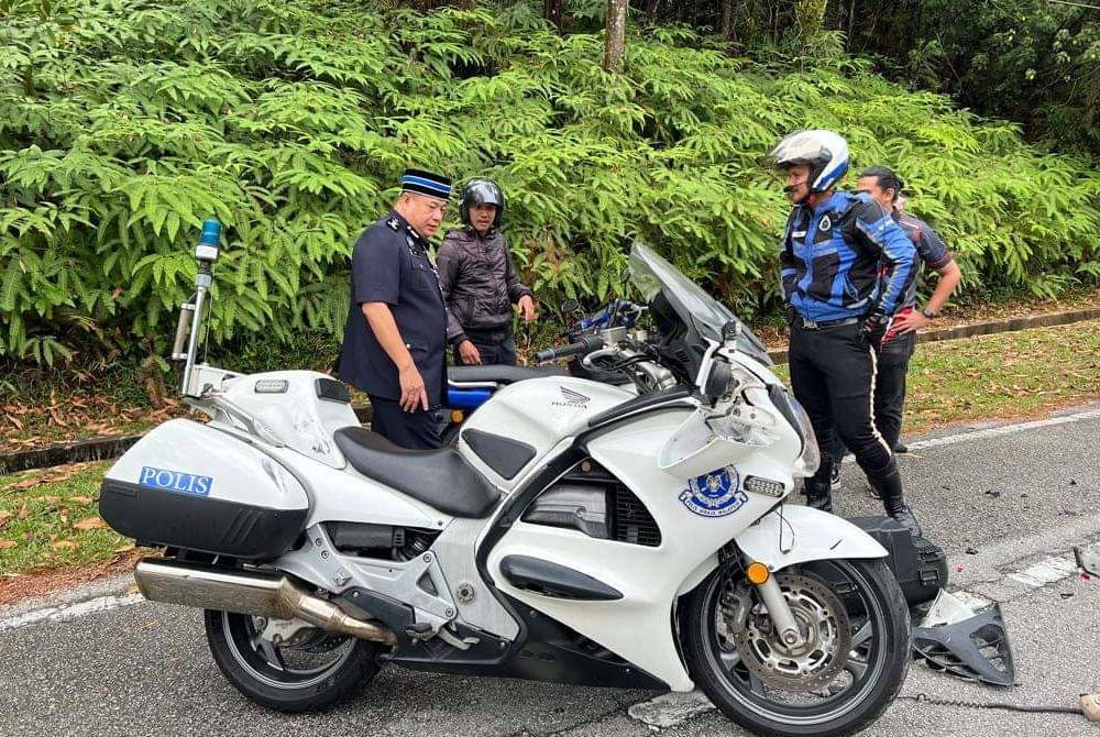 Azizi (kiri) melihat keadaan Mohd Faizol yang dilaporkan cedera ringan ketika menjalankan tugas. Foto ihsan Facebook Polis Perak