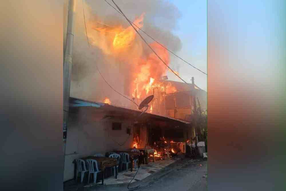 Anggota bomba giat memadam kebakaran melibatkan sebuah rumah dan kedai di Jalan Mat Raji, Padang Jawa, Shah Alam, Selangor pada Selasa. Foto JBPM.