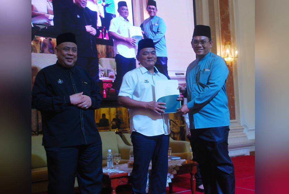 Rahmad (tengah) menyampaikan sijil pentauliahan kepada seorang penceramah selepas majlis penutupan Program Wacana Hadis Sempena Maal Hijrah Peringkat Negeri Melaka di Jalan Hang Tuah pada Selasa.