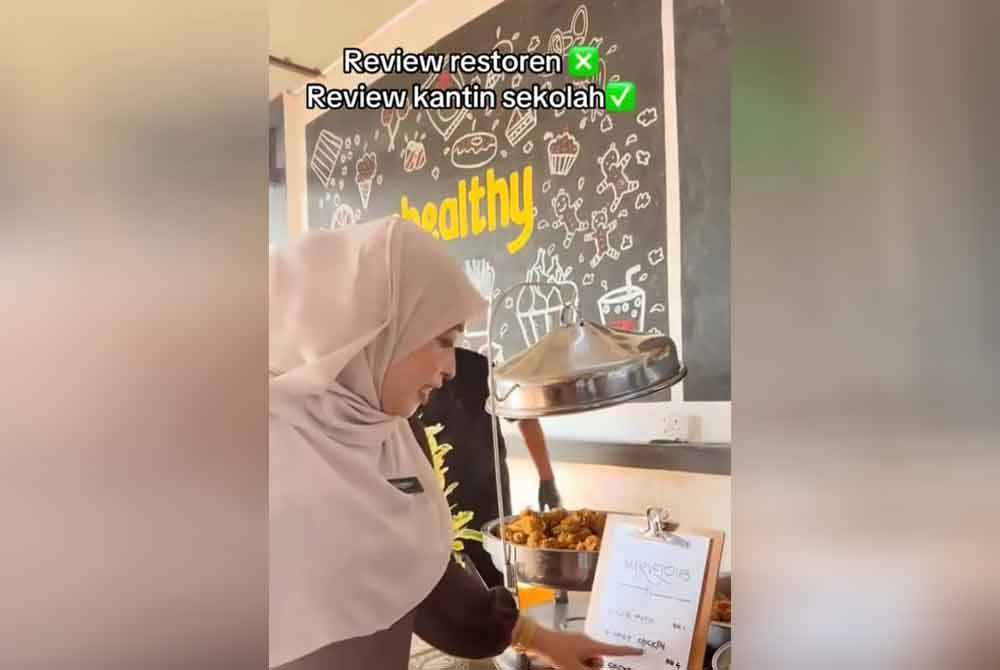 Cikgu Siti sedang memberi penerangan tentang menu makan yang dijual di kantin SMK Saujana Utama, Sungai Buloh