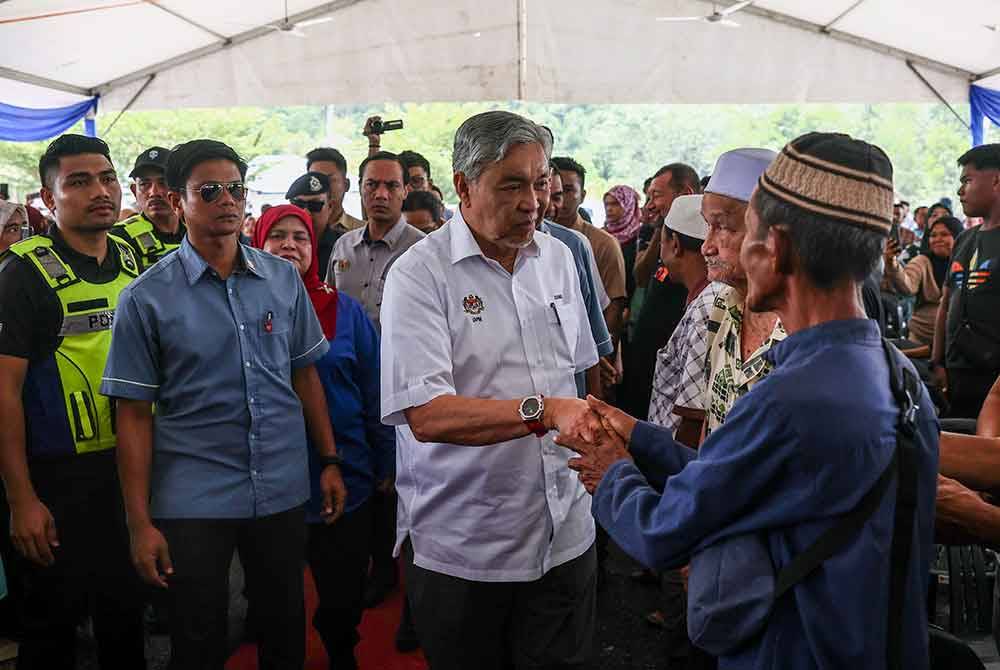 Ahmad Zahid bersama penduduk kampung ketika hadir pada Majlis Pelancaran Pelan Pembangunan Pusat Pertumbuhan Desa (PPD) Sungai Asap pada Selasa. Foto Bernama