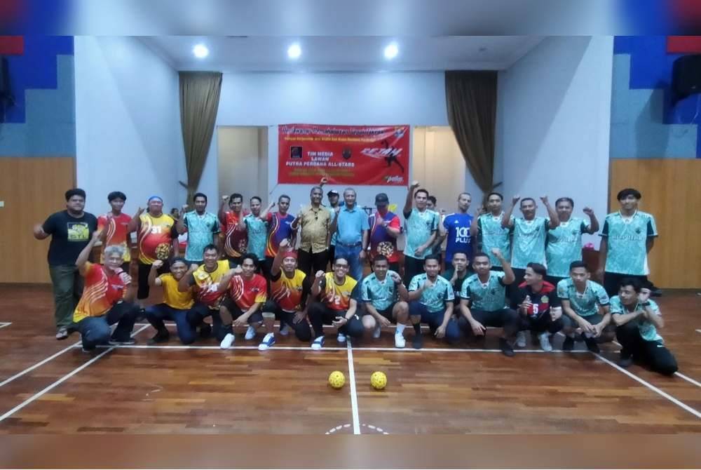 Barisan pemain Tim Media (jersi merah kuning) dan Kesputra melaungkan sorakan semangat sebelum perlawanan persahabatan di Dewan Komuniti Putra Perdana, Puchong.