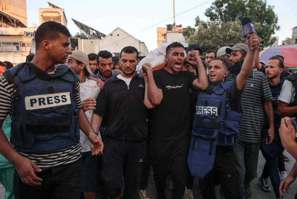 Orang ramai membawa jenazah wartawan Al-Jazeera, Ismail al-Ghoul yang terbunuh bersama jurukameranya, Rami al-Refee dalam serangan Israel semasa membuat liputan mereka ke atas kem pelarian Al-Shati di Gaza. Foto Bernama