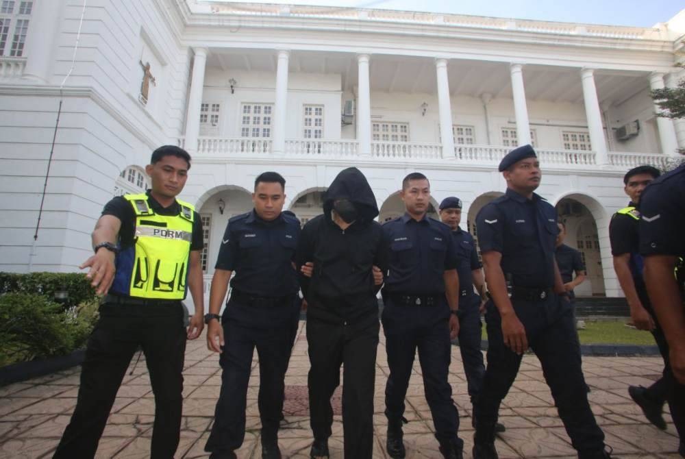 Tertuduh dikawal dan diringi polis ketika dibawa masuk ke Mahkamah Tinggi Ipoh pada Khamis.