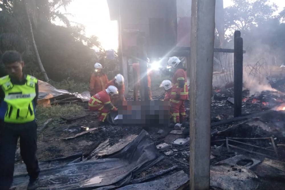 Anggota bomba mengangkat salah seorang mayat mangsa kebakaran di Kampung Blok 5, Pitas pada Khamis.