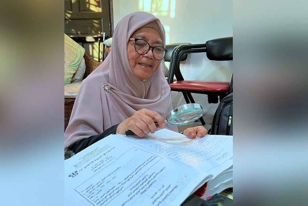 Siti Zaharah menggunakan kanta pembesar, menelaah satu persatu kitab dan buku di kediaman kecilnya di sini. Foto Bernama