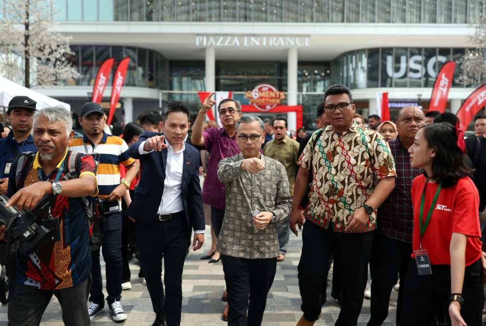 Fahmi ketika melawat bazar dan beramah mesra dengan peniaga ketika hadir pada sambutan 6 Tahun J&T Express Malaysia dan melancarkan Program J&T Hantar #KasiJadi di pekarangan Piazza @ Pavillion Bukit Jalil hari ini. Foto Bernama