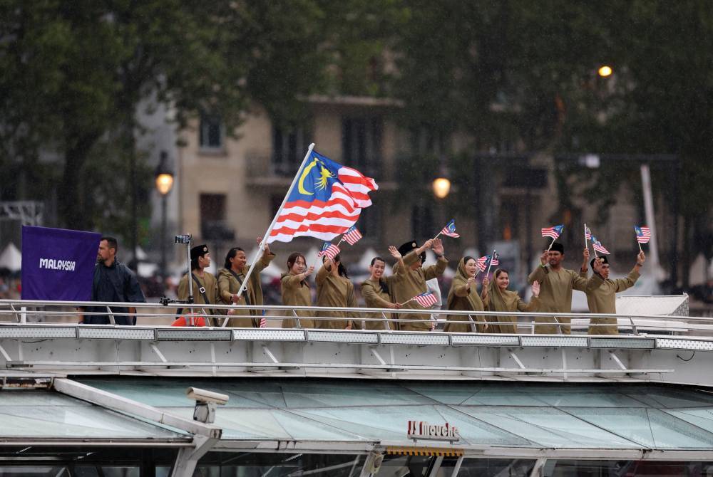 Atlet Malaysia mengibarkan Jalur Gemilang ketika berlayar di sepanjang Sungai Siene semasa upacara pembukaan Sukan Olimpik Paris 2024 di Paris, Perancis. Foto Getty Images