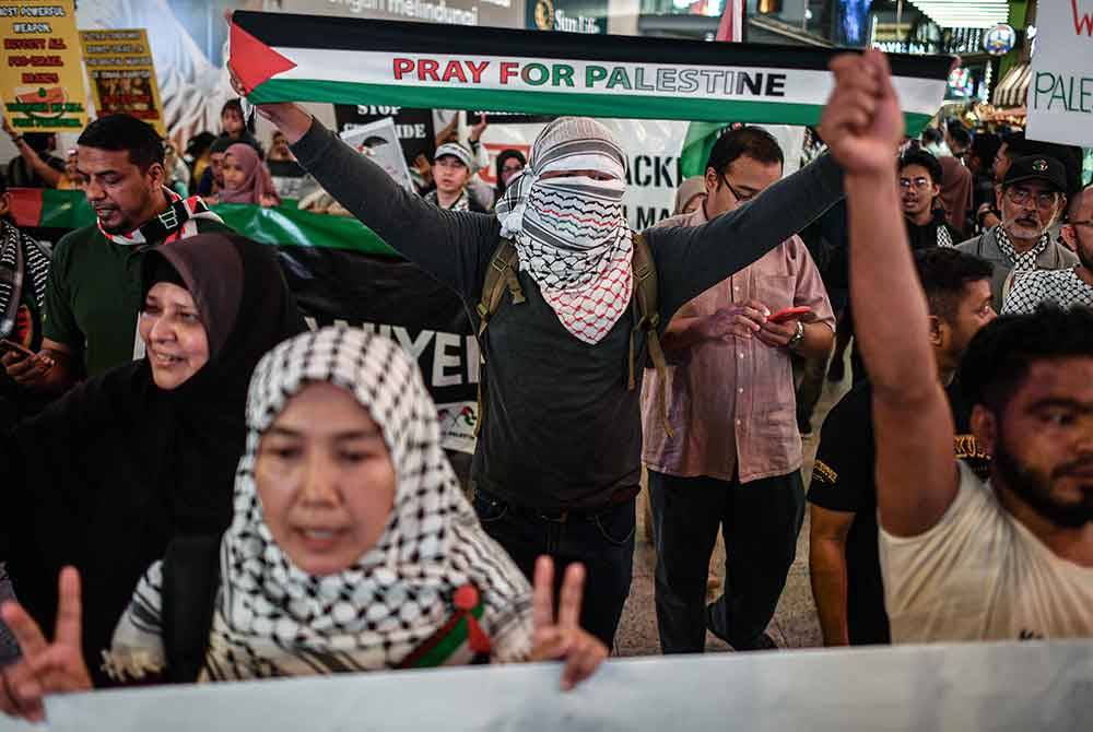 Para peserta Solidariti Antarabangsa bersama Palestin menyatakan solidariti kepada rakyat Palestin di sekitar Bukit Bintang malam tadi. Foto Bernama