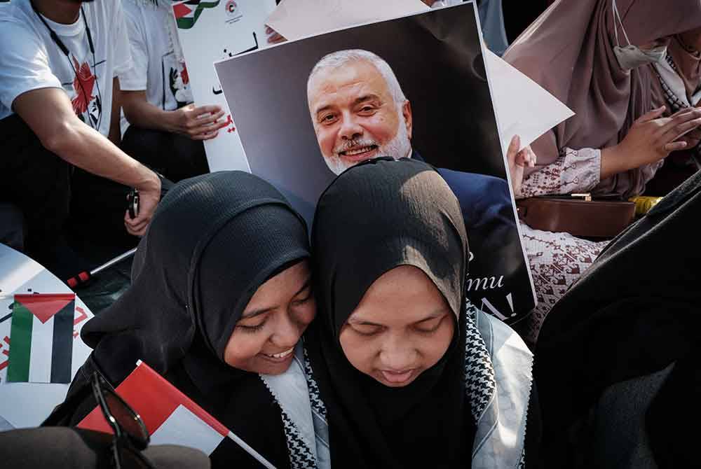 Poster Ismail Haniyeh kelihatan semasa himpunan warga Indonesia menyatakan solidariti terhadap Palestin di depan Kedutaan Amerika Syarikat di Jakarta pada Sabtu. Foto AFP