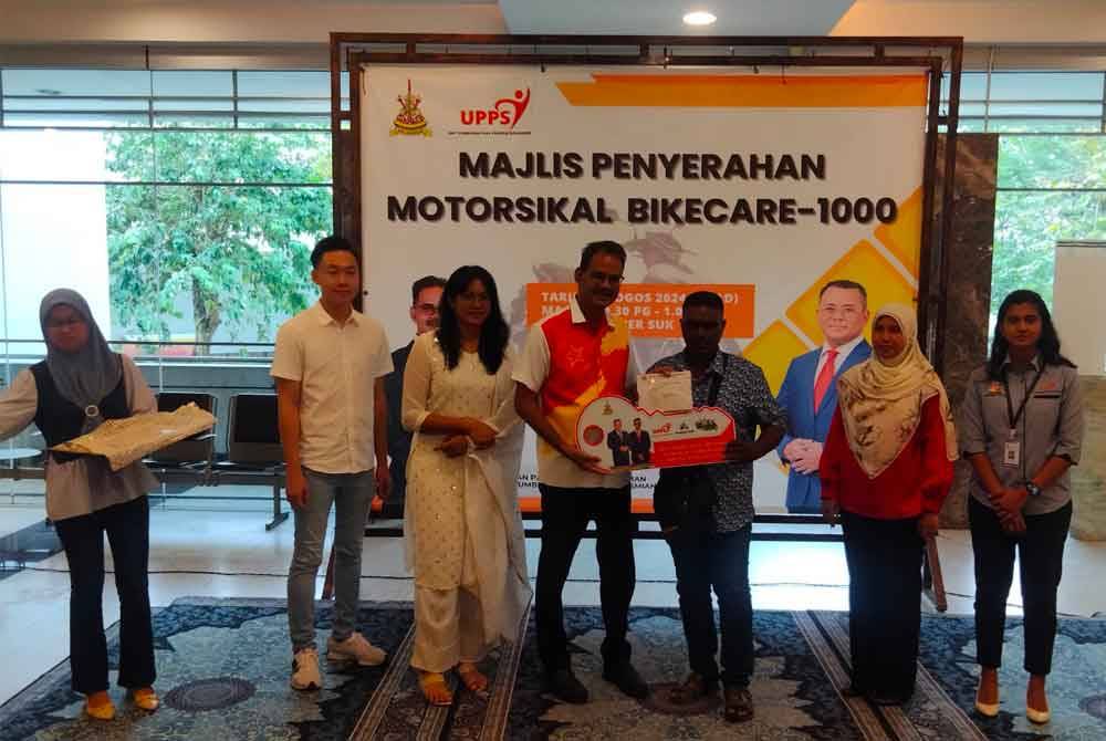 V Papparaidu (empat kanan) menyampaikan bantuan bayaran pendahuluan motosikal menerusi Program BikeCare-1000 berjumlah RM1,000 kepada setiap seorang