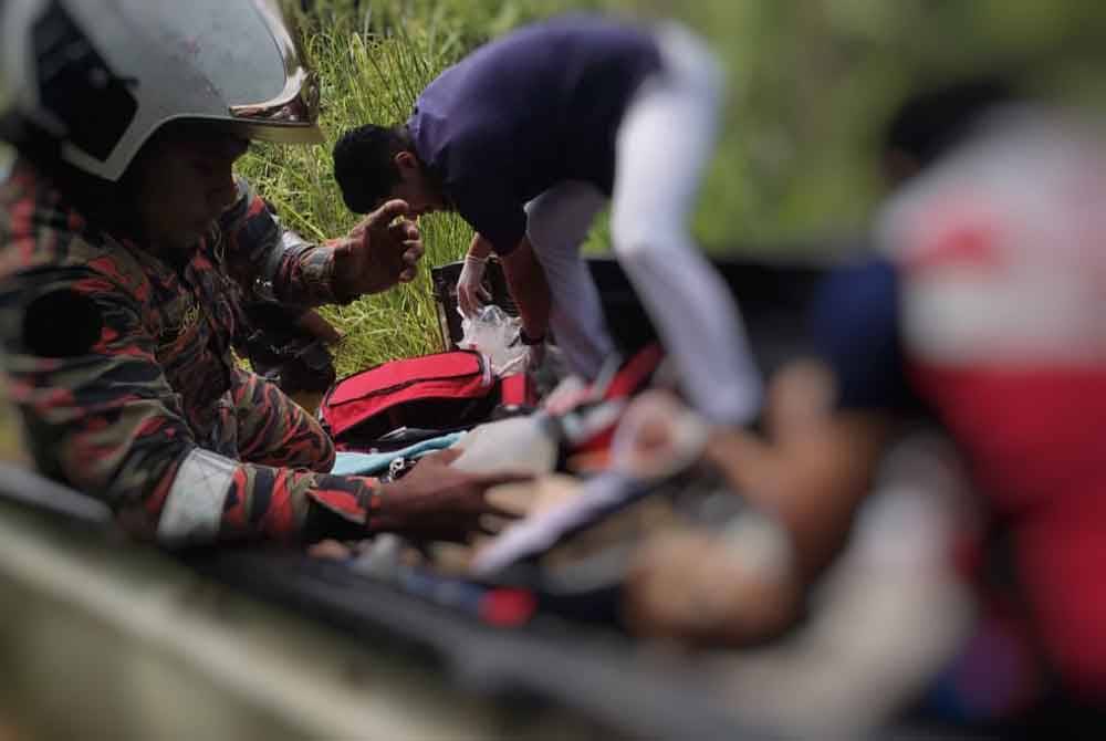 Anggota bomba membawa mangsa yang dihempap pokok ketika memancing di kawasan hutan di sekitar Sungai Kechau pada Ahad. Foto JBPM Pahang