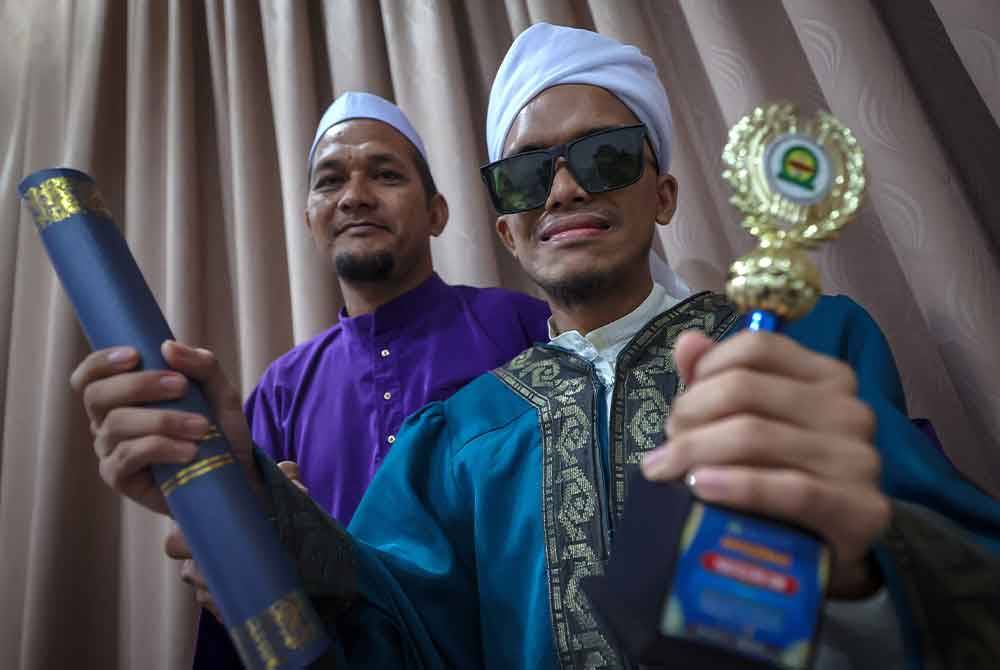 Amzar Haziq (kanan) bersama bapanya, Md Fauzi Md Noor, 47, menunjukkan sijil dan piala Anugerah Hafazan Am ketika ditemui pada Majlis Konvokesyen Huffaz Nusantara kali ke-9 di Dewan Millenium pada Ahad. Foto Bernama